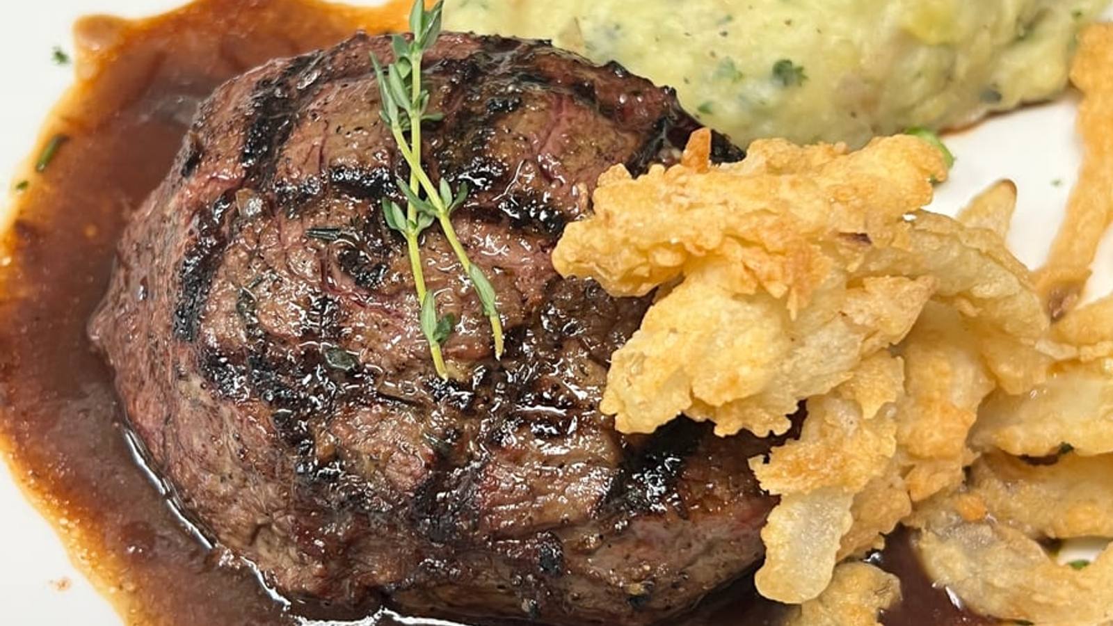 A hand-cut Angus sirloin finished with roasted garlic thyme butter and crisp fried onion