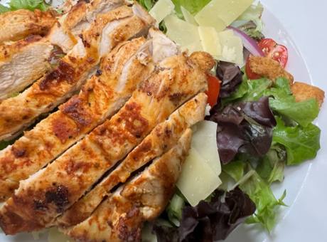 Sliced grilled chicken breast over mixed greens with shaved parmesan and grape tomatoes